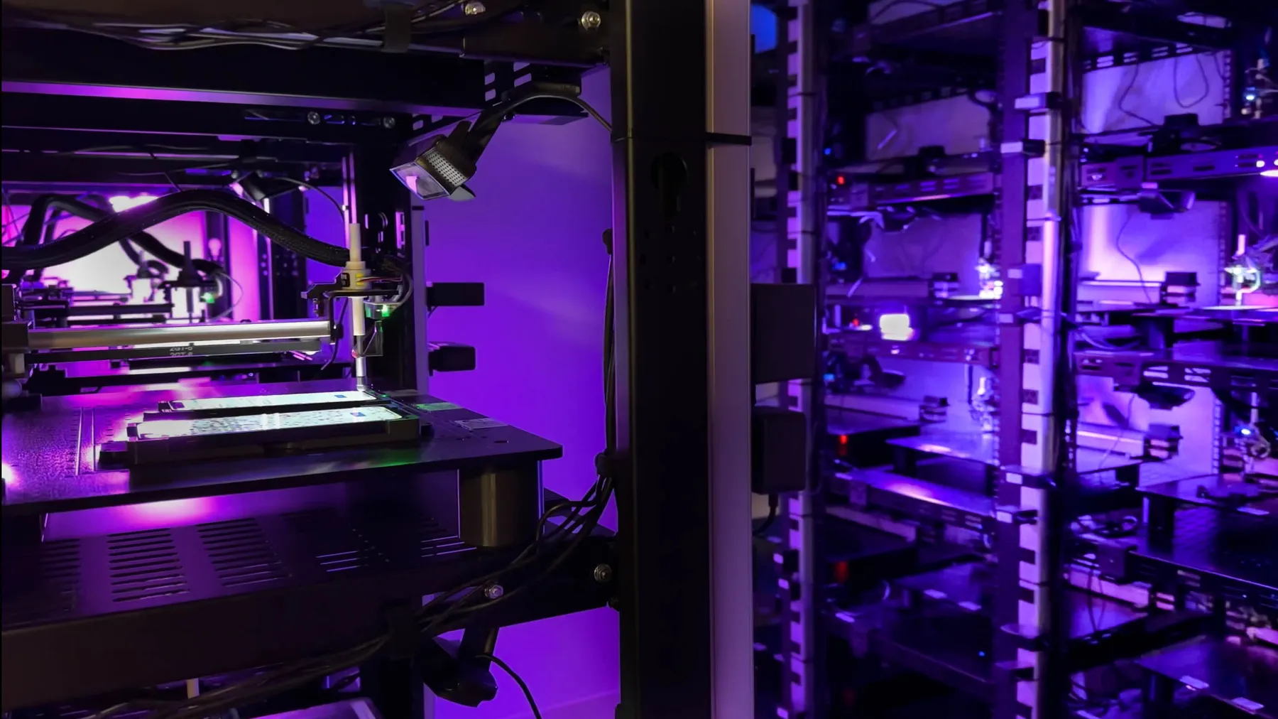 Wide view of the lab with a rack of robot cells, each holding a phone